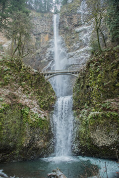 Multnomah falls with bridge over mossy cliffs in Oregon forest