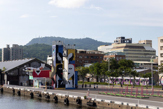 Kaohsiung, Taiwan - September 8, 2025: A painted tower and light rail train at Pier-2 Art Center by the harbor.