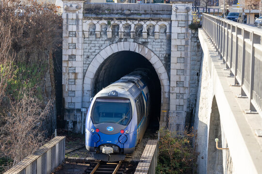 Entrevaux, France - December 26, 2025: A blue train passes through the station and enters a stone tunnel.