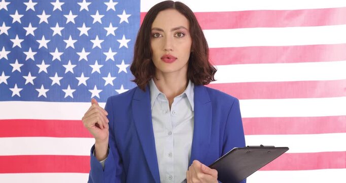 American politician delivers passionate speech to voters. Confident woman canvasser expresses strong political views standing against American flag