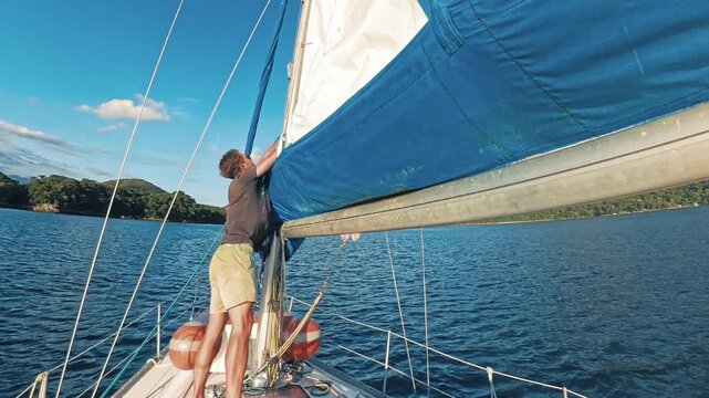 Timelapse of the person rolling main sail on the sailing boat