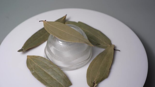 Bay leaf Cinnamomum tamala dried herb spice seasoning rotate on white surface studio shot commercial video clip