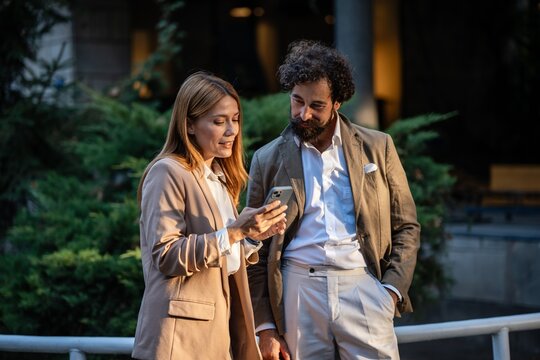 Business people using smartphone outdoors in the city