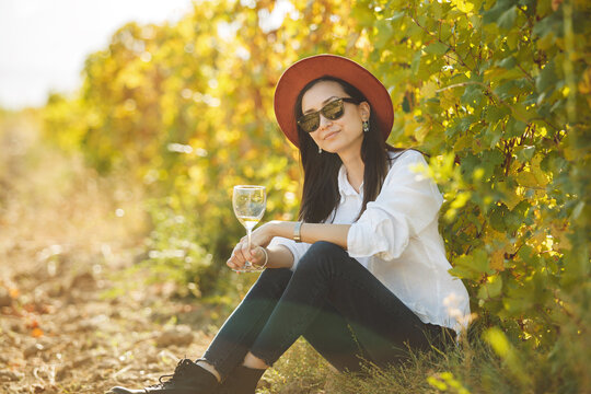 Woman Enjoying Glass of Wine in Vineyard Field