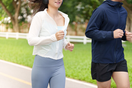 Asian man and woman jogging together in park for fitness training lifestyle