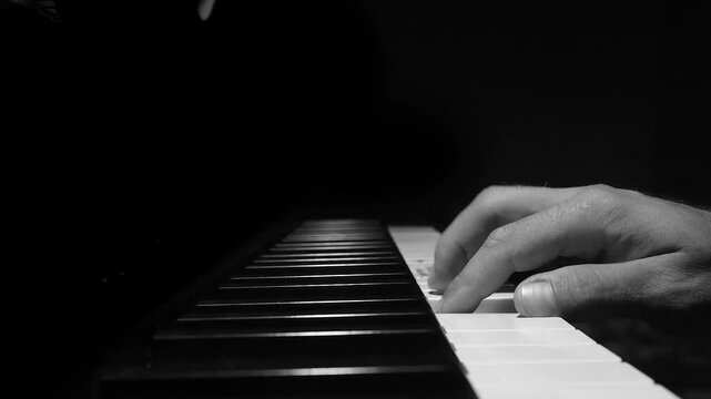 Monotony concept with a player repeating same tune on piano keys. Static shot close up of a person hand in training practice, dramatic dof light