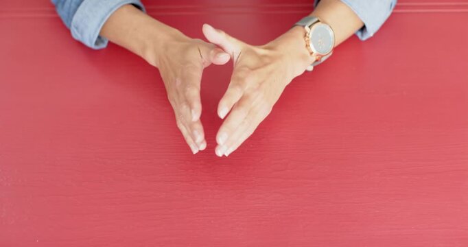 Close up of people talking to the camera, hands resting on table, person wearing watch and denim shi