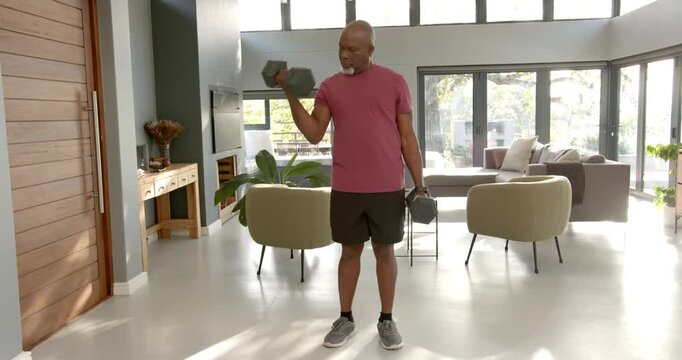 Lifestyle videos indoor of people doing activities at home, lifting dumbbells, man exercising in mod