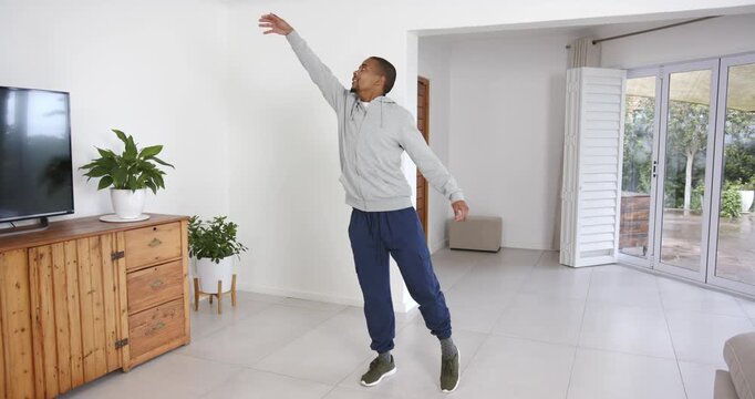 High speed photography for dynamic scenes, stretching arm upwards, man exercising indoors in living