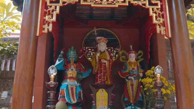 An altar dedicated to the Chinese philosopher Confucius, located at the Temple of Literature in Hanoi, Vietnam features colorful statues of Confucius and his disciples. Shot in motion

