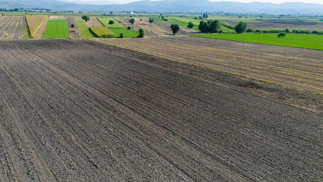 Aerial View of Plowed Farmland and Green Fields in Valley