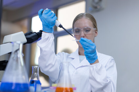 Women scientist using pipette to prepare sample during laboratory research for scientific experiment, biotechnology, chemical analysis, medical testing, microbiology, healthcare innovation.