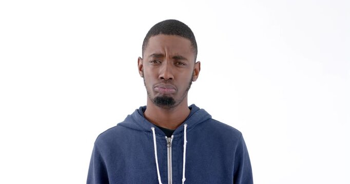 Young man in blue hoodie expressing confusion against white background