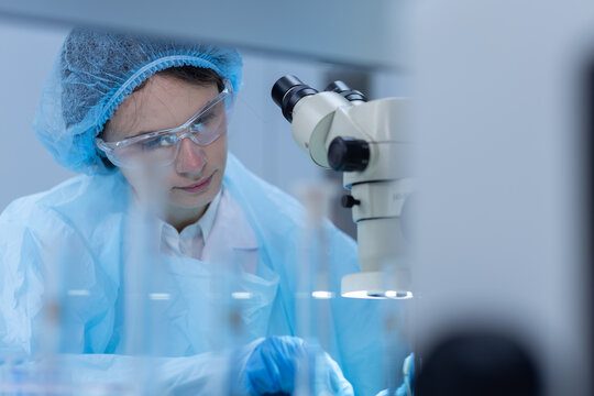 Women scientist operating microscope equipment in laboratory for scientific research, sample analysis, biotechnology, microbiology, medical testing, precision science, laboratory safety.