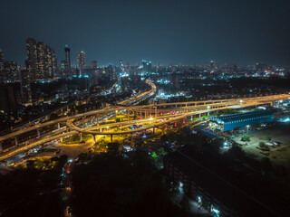 Fototapeta premium A stunning aerial night view of Atal Setu (Mumbai Trans Harbour Link), showcasing the intricate network of illuminated flyovers and highways glowing in golden light.