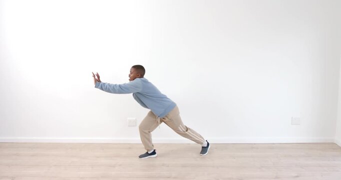 Young boy practicing balance exercises against white wall, focusing on stability