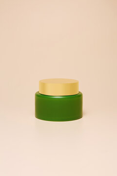 Green cream jar on beige background