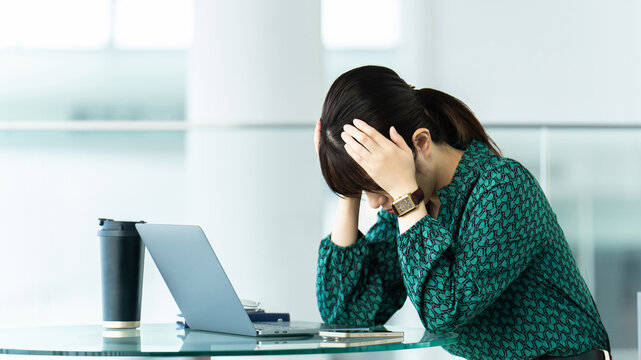 頭を抱えて悩む女性・ビジネスウーマン, Stressed Businesswoman Working on a Laptop
