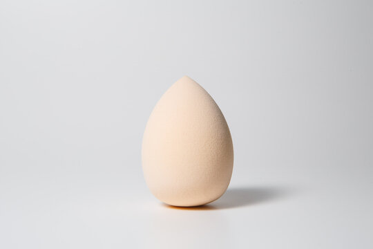 Closeup beige makeup sponge on gray background