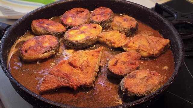 Atlantic bonito steaks frying in hot oil in a pan during home cooking