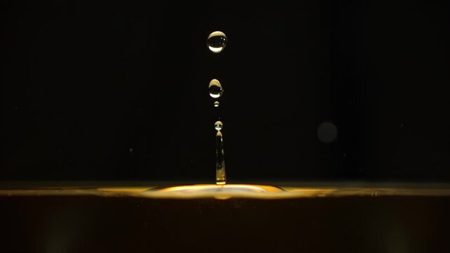 Golden cosmetic serum drop falling in macro. Collagen essence, skincare fluid and beauty product formulation