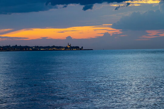Luci sul litorale con cattedrale di Giovinazzo ( Bari , Puglia , Italia ) al tramonto