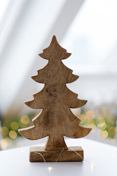 Wooden Christmas tree decor and warm fairy lights, festive holiday home decoration, cozy winter season still life on table with copy space and glowing bokeh background