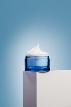 Minimal blue cosmetic cream jar on pedestal