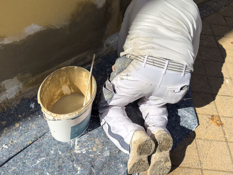 construction worker with trowel Plastering a house wall with textured plaster.