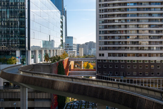 Elevated pedestrian walkway between modern buildings in Paris, France, showing urban circulation and contemporary architecture in a business setting.