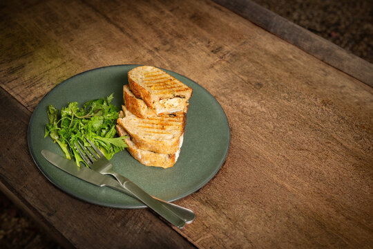 Top view of a sliced grilled panini sandwich on ceramic plate.