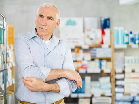 Elderly man with pain in arm in pharmacy