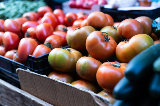 Different of ripe tomatoes offered for sale on counter of local vegetable market