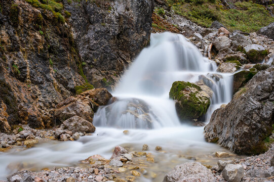 Long exposure of a mountain stream and small waterfall over rocks in Silberkarklamm, Austria