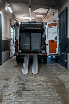Loaded Cargo Van with Wheeled Containers and Metal Loading Ramps
