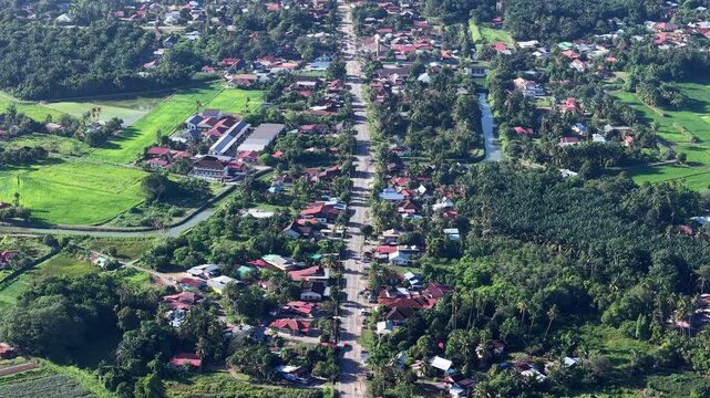 Aerial shot captures a peaceful village layout. Main road stretches through red roofed homes at Kubang Semang