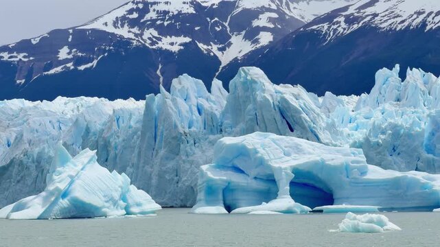 Majestic view of the Perito Moreno Glacier in Patagonia, Argentina. Icebergs floating on the cold water with snowy mountains in the background
