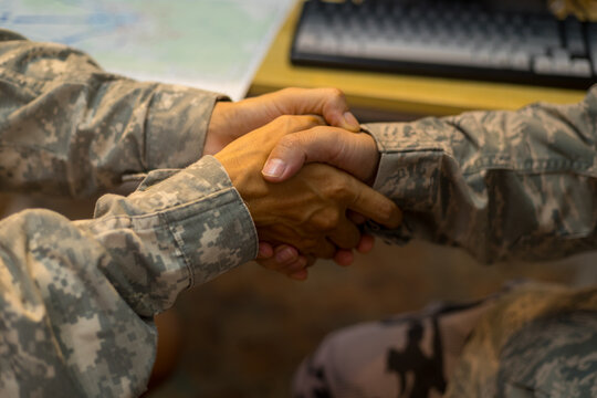 Experienced military hands focused intensely around a tactical map table, actively collaborating and planning precise strategic operations, operational logistics