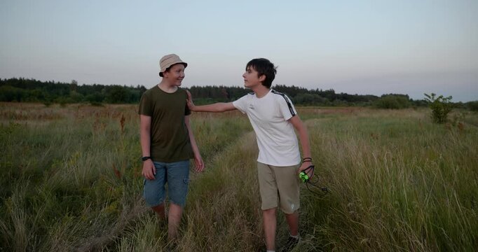 Two boys walk hiking on nature. Teenagers spending time together. 4K 10-bit