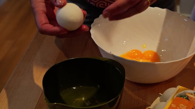 Woman separating egg yolk from white