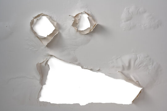 Peeling plaster detached from ceiling with damaged paint and holes caused by water infiltration and humidity. Home damage from mold and leak needing renovation and repair work.