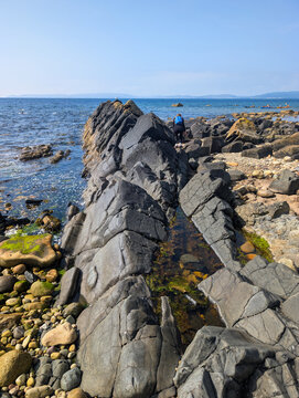Rugged black rock formations jut from turquoise sea