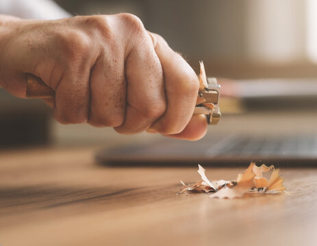 Hand sharpening pencil with manual sharpener on desk