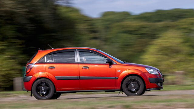 Milton Keynes; UK - Sept. 20th 2026: 2009 red Kia Rio diesel engine hatchback car driving on a British road