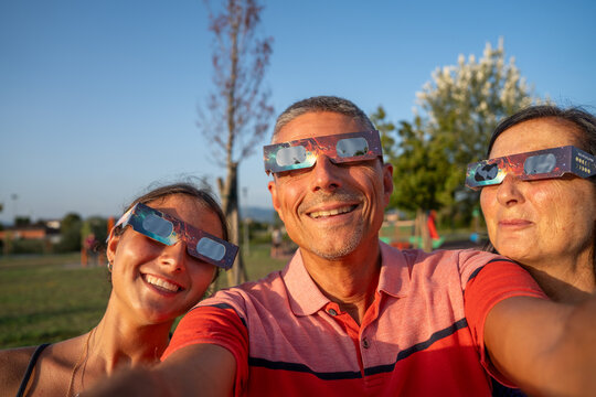 Parents and child watching total solar eclipse together with wonder and emotion