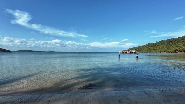 Peaceful tropical bay with pier and distant hills