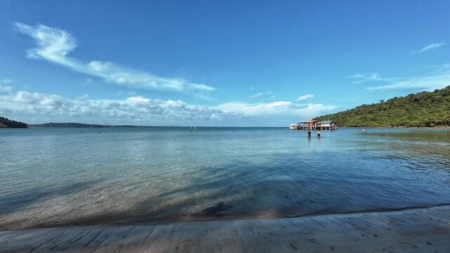 Calm turquoise bay with wooden pier and shoreline