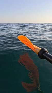 Kayaking journey across calm open sea waves during quiet morning excursion. First person perspective medium shot.