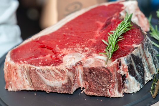 Raw steak presented on white plate in restaurant with fresh meat detail