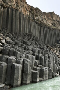 Dramatic hexagonal basalt columns rising from turquoise coastal